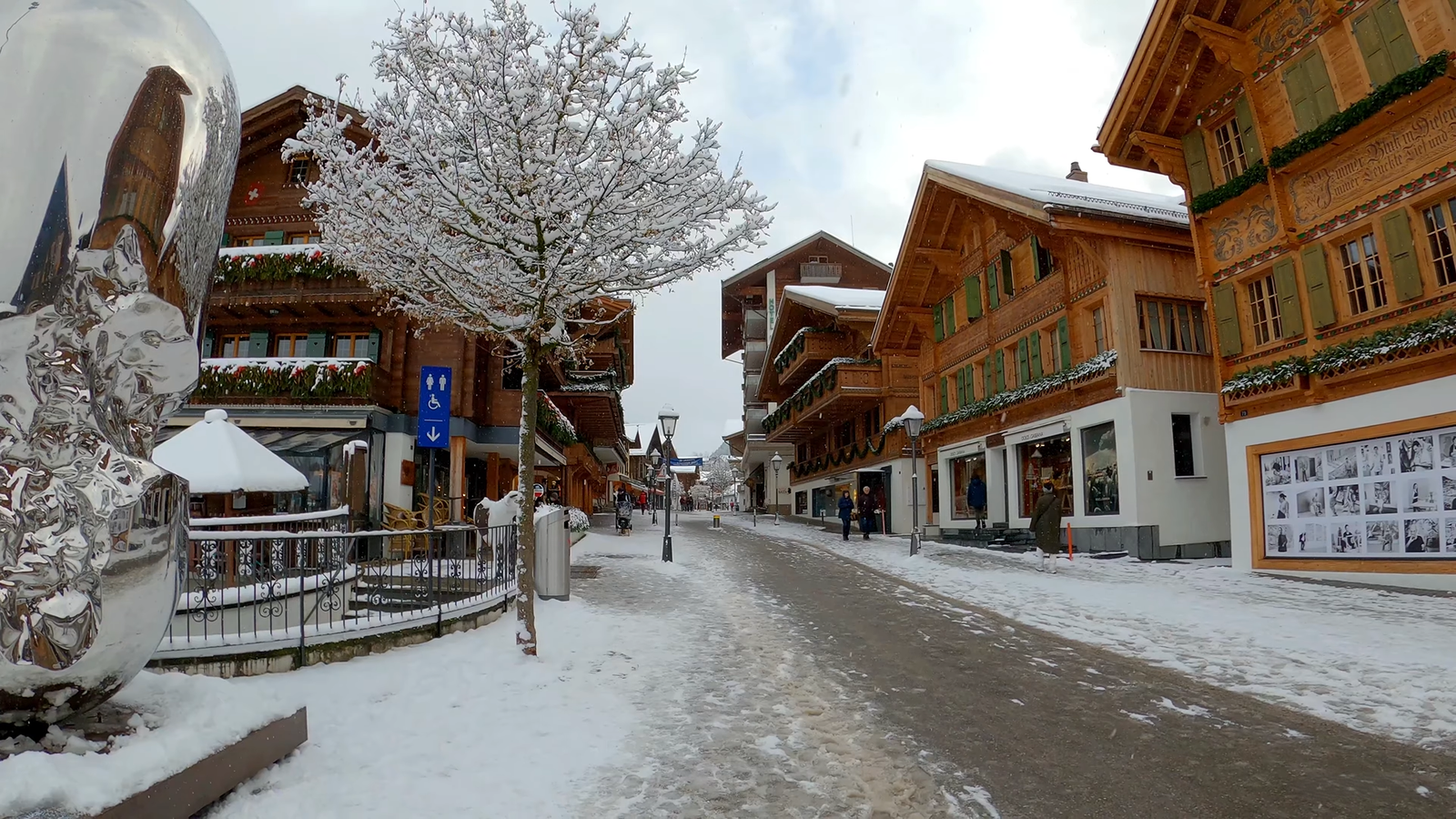 Snow-covered chalets and pine forest below the landmark Gstaad Palace hotel in the Swiss Alps.